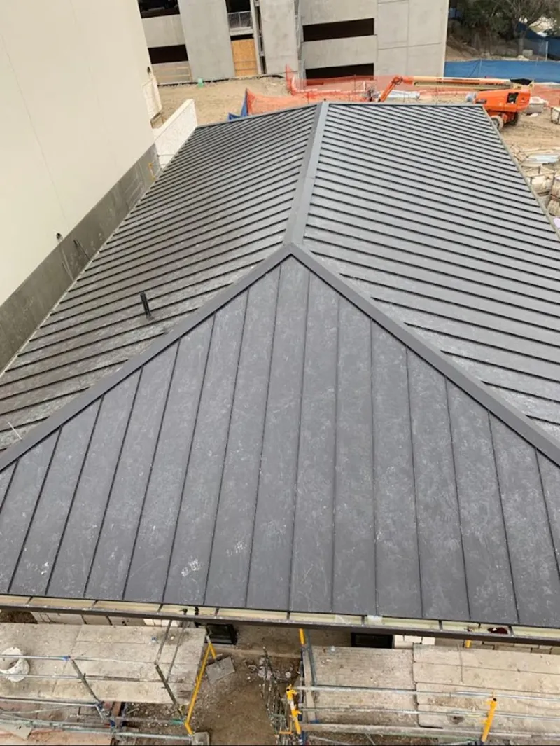 Commercial metal roof construction with crane equipment in Hopedale